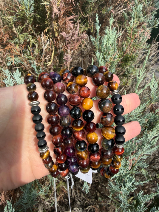 Assorted Tiger’s Eye beaded bracelets in golden, red, and blue varieties with polished gemstone beads.