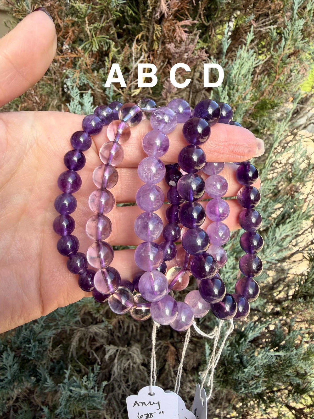 Polished amethyst beads showing variations of lavender and deep purple.