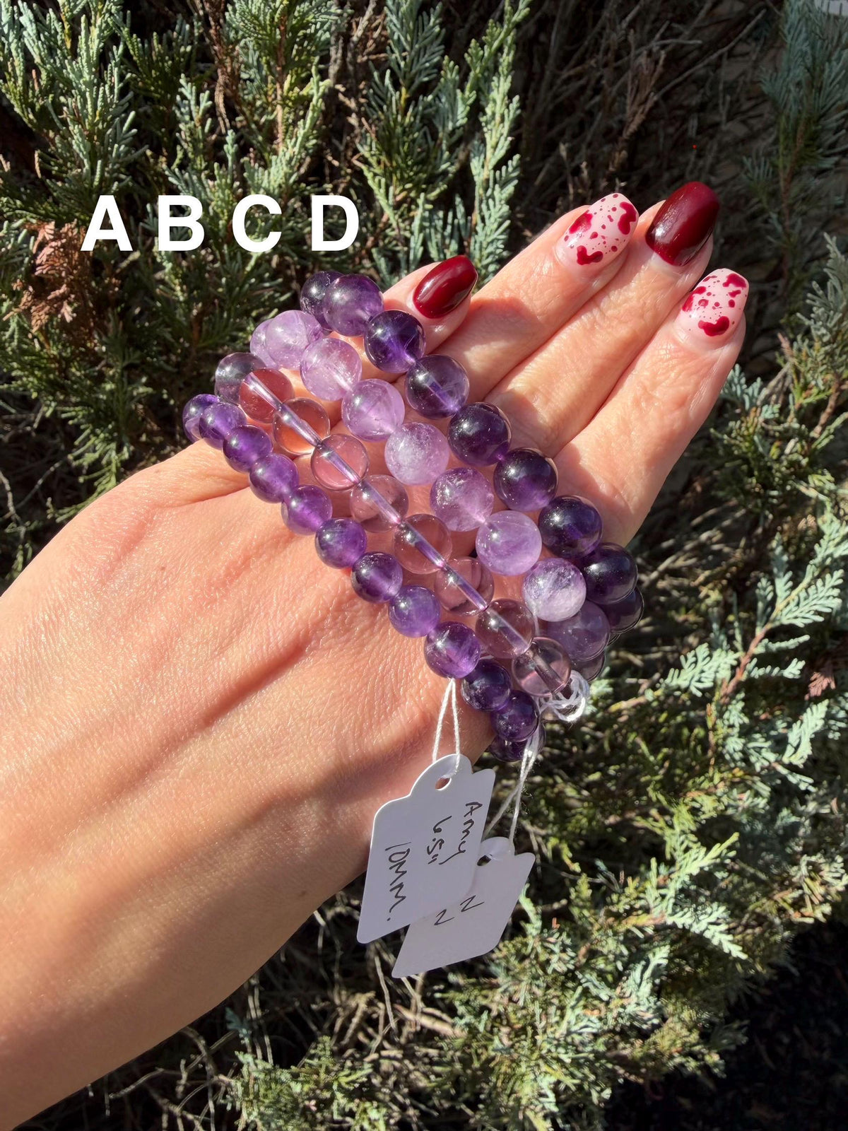 Amethyst bracelets in 6mm, 8mm, and 10mm bead sizes arranged side by side.