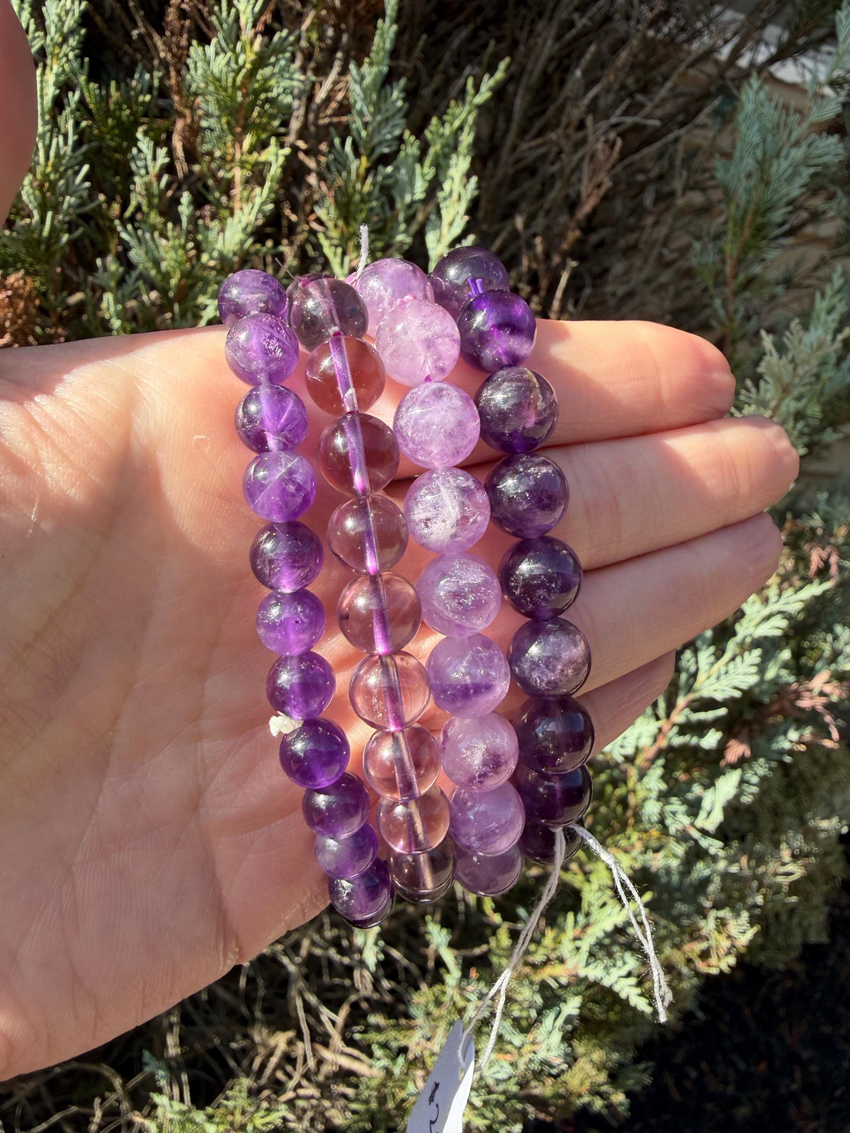 Assorted amethyst beaded bracelets in multiple bead sizes with natural purple gemstone beads.