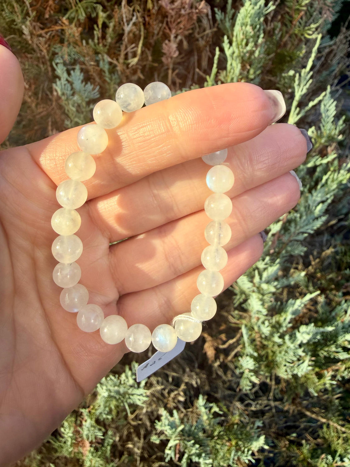 Flashy White Moonstone bracelet with 7.5mm beads sized for a 6-inch wrist showing blue and silver iridescent flash.