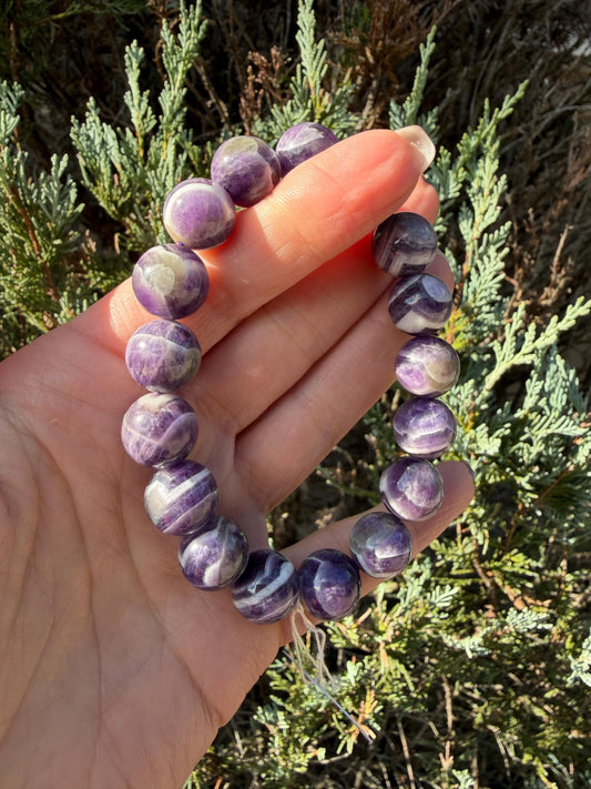 Polished Chevron Amethyst beads showing distinctive purple and white zigzag patterns.