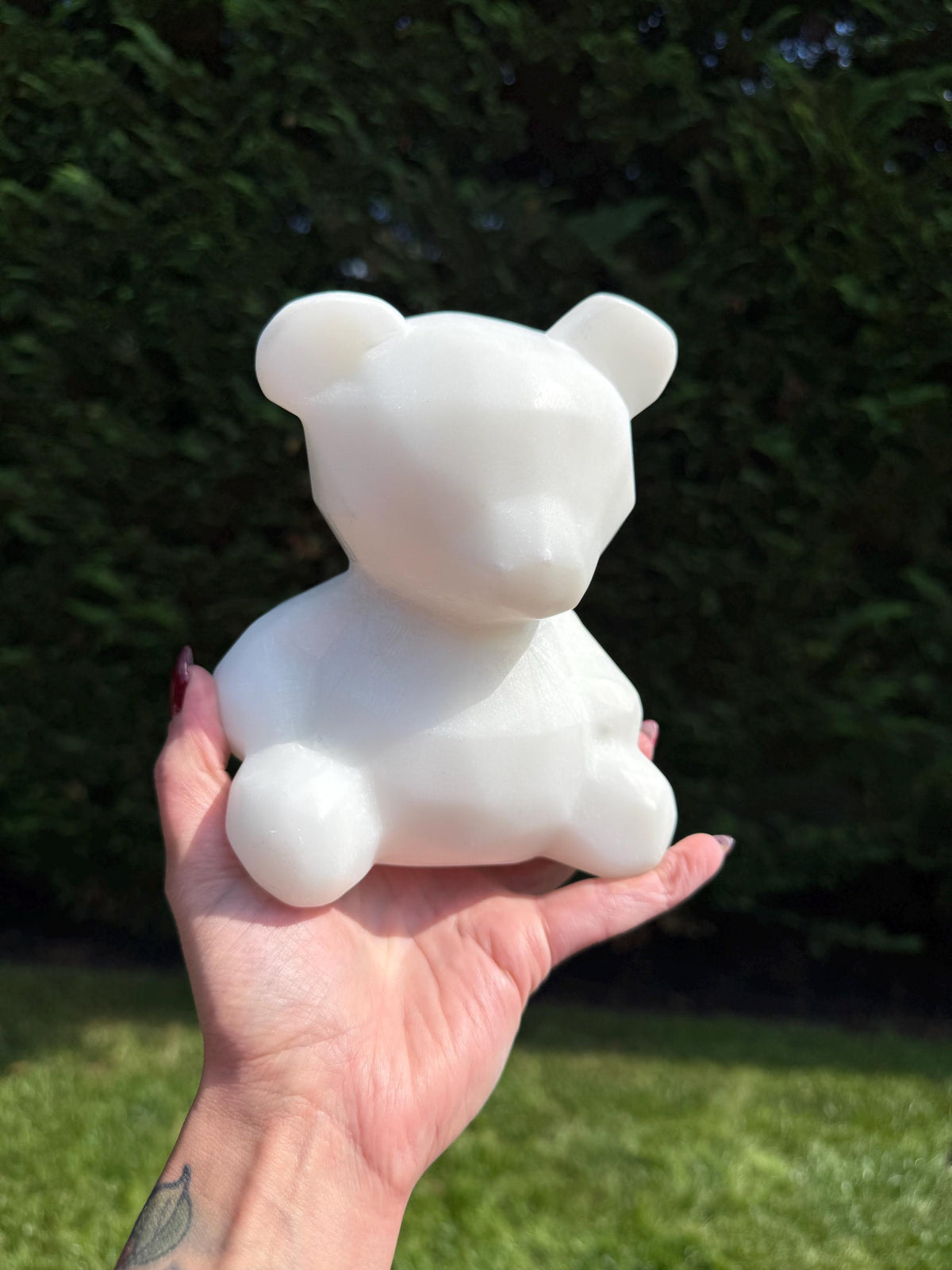 Close-up of white jade bear showing detailed carving and natural stone texture.