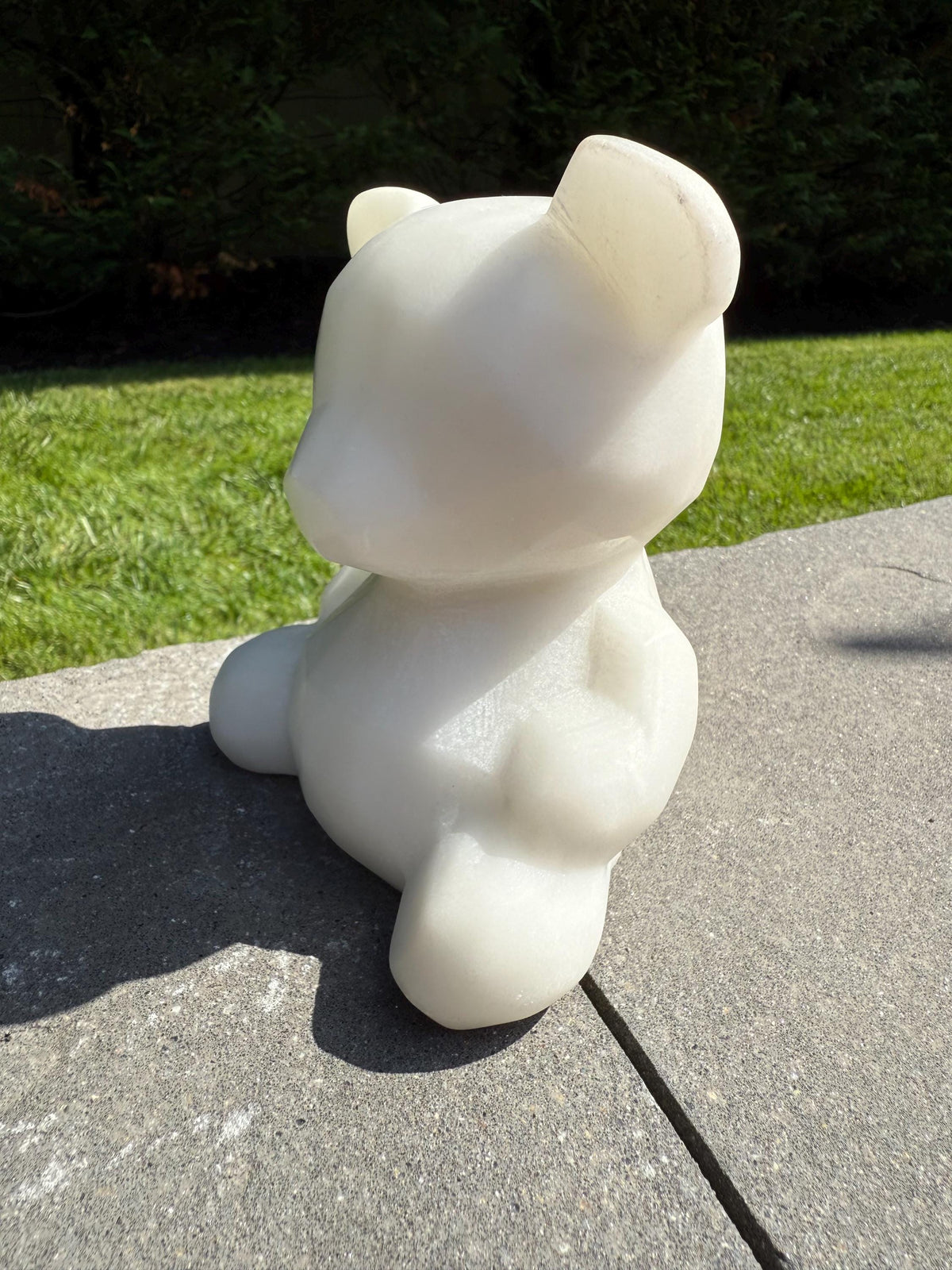 Side view of XL white jade bear highlighting carved features and smooth polish.