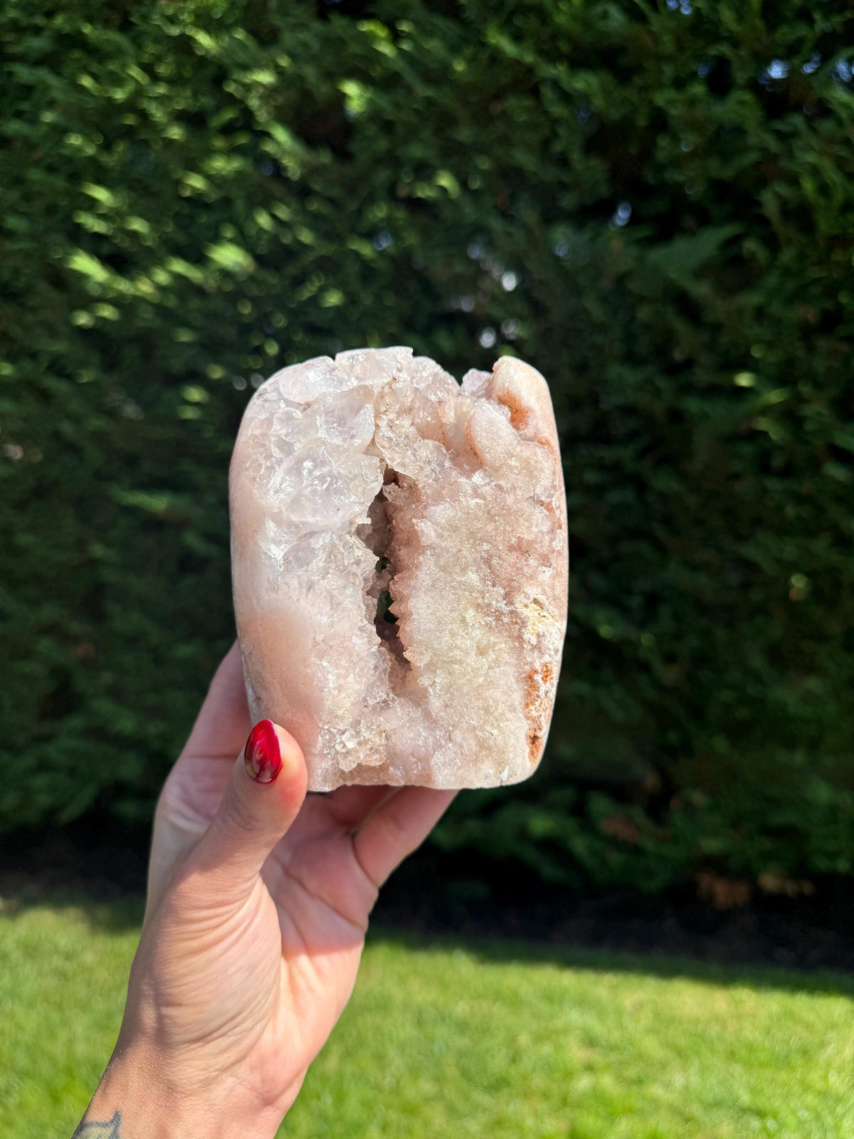 A large pink amethyst crystal freeform from Brazil featuring sparkling druzy pockets and soft pastel pink tones. The stone has a polished surface with natural texture and a self-standing shape, showcasing shimmering crystal clusters.